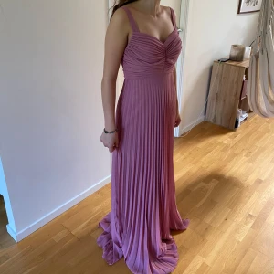 Balklänning NY!  - Elegant rosa balklänning. Endast provad. Köpt i London för 2500kr. Jag är 158 cm och har ej klackat på mig på bilden. 