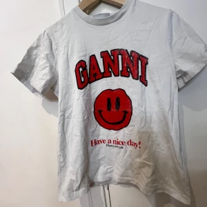 Vit t-shirt från Ganni med smiley - Säljer en vit/röd ganni t shirt endast använd ett fåtal gånger! Pris går att diskutera!
