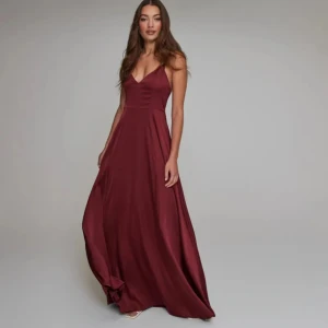 Vinröd balklänning  - Långklänning i nyskick endast använd en gång, med lappen kvar ordinarie pris 1200 kr. Köparen står för frakt