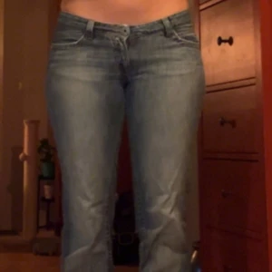 Blå jeans från Edc by Esprit - Snygga blå jeans från Edc by Esprit med en klassisk bootcut-stil. De har en låg midja och är tillverkade i ett bekvämt denimtyg. Perfekta för en avslappnad look med en dragkedja och knapp framtill. Har en liten slitning vid rumpan men den syns inte