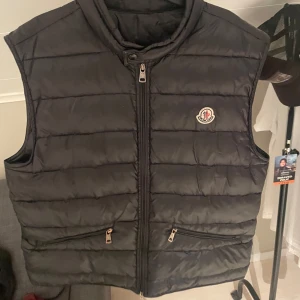  Moncler väst  - Snygg svart dunväst från Moncler med dragkedja och två fickor framtill. Västen har en quiltad design och ett Moncler-märke på bröstet, tag funkar även. Pris kan diskuteras vid snabb och smidig affär🤝🏻