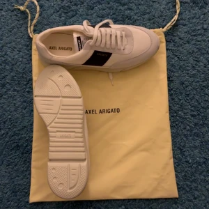 Axel Arigato Genesis vintage  - vita - Snygga vita sneakers från Axel Arigato med svarta detaljer. Skick: 10/10 (fläckfria). Pris 1400kr. Nypris: 2500kr. Vid frågor tveka inte att skriva!