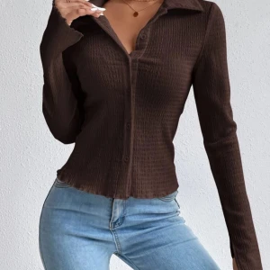 Brun ribbad skjorta - Säljer en snygg brun ribbad skjorta. Skjortan har långa ärmar och knappar framtill. Perfekt för en stilren look. Passar bra till jeans eller kjol. 🧡