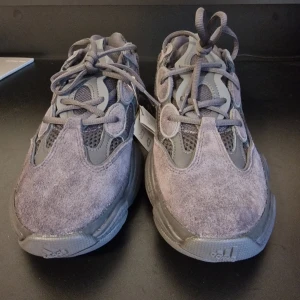 YEEZY BOOST 500 - Snygga grå sneakers från Adidas med en unik design. Skorna har en kombination av mocka och meshmaterial, vilket ger dem en modern look. De har snörning och en robust sula för extra komfort. (Finns order bekräftelse från Adidas om det önskas för bevis att de är äkta) 