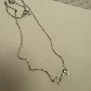 Silverhalsband med jungfru  - Fint silverhalsband (sterling silver) med en unik stjärnbildsdesign. I tecknet jungfru! Aldrig använt! 