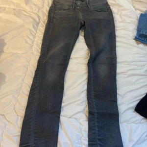 Grå jeansbyxor från G-Star RAW - Snygga grå jeansbyxor från G-Star RAW med klassisk femficksdesign och knappgylf. Byxorna har en stilren look med subtila detaljer och en bekväm passform.