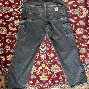 Svarta carpenters från Carhartt - Säljer ett par svarta arbetsbyxor från Carhartt med praktiska fickor och robust design. Byxorna har är baggy så passar alla bra. Markerade som 31x32 men mer likt 32x32. Inga större fläckar.