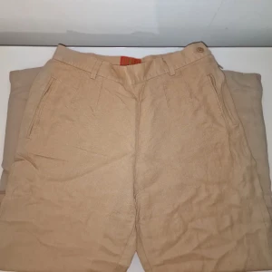 Beige linnebyxor från Kenzo Jungle - Snygga beige linnebyxor från Kenzo med en klassisk design. Perfekta för en avslappnad och stilren look.