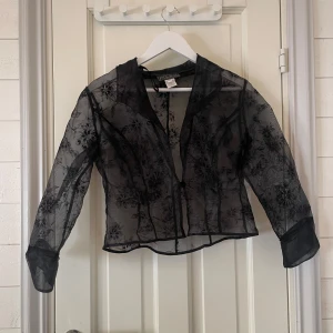 Svart transparent blus  - Snygg svart transparent blus från Alex Evenings med blommigt mönster. Nästan trekvartsärmar. Köpte secondhand på beyond retro för 195kr till en konsert men använde aldrig. (Pris kan diskuteras) Om man vill se hur den ser ut på är det bara att fråga😊.                                                           10p står för en M i petit storlekar om jag förstår det rätt. Den är lite kort för mig med lite större byst och jag är normalt sätt en S-M i tajtare tröjor för referens. 