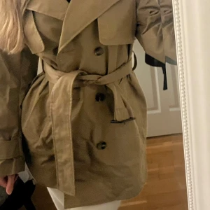 Trenchcoat storlek S  - Säljer en kort trenchcoat/ kappa från zara värde 999 kr. Den är oanvänd. Säljer för 299 kr (pris kan diskuteras). Storlek s 