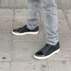 Svarta sneakers med vit sula - Snygga svarta sneakers med vit sula från LANVINS. Skorna har en glansig finish på tån och är perfekta för en stilren look. ( lanvins ) 