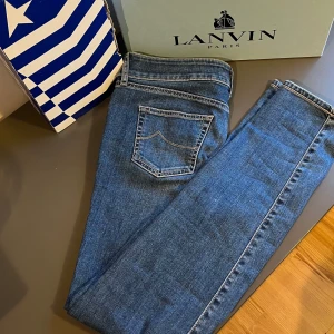 Blå jeans från Jacob Cohen - Snygga blå jeans från Jacob Cohen med klassisk femficksdesign och knappgylf. Jeansen har en normal passform och är tillverkade i ett slitstarkt denimtyg. Perfekta för en avslappnad stil och är i skick 10/10. Storlek 29 och passar mellan 170/160 och mellan 50-60 kg 😇