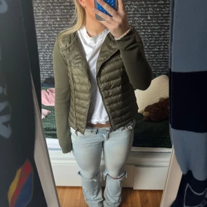 Olivgrön jacka från Moncler - Snygg olivgrön jacka från Moncler med dragkedja och quiltad design. Jackan har en tight passform och långa ärmar, perfekt för höst och vår. Den är tillverkad i syntetmaterial och har en stilren look.