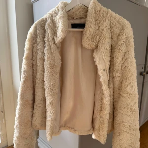 Beige teddyjacka från Vero Moda - Mysig beige teddyjacka från Vero Moda. Defekter som inte syns när man har på sig den syns på de två sista bilderna