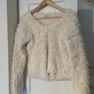 Vit fluffig tröja från ONLY - Säljer en supermjuk och fluffig vit tröja från ONLY. Perfekt för att hålla sig varm och stilren under kyliga dagar. Tröjan har långa ärmar och en mysig textur som ger en unik look. Passar perfekt för både vardag och speciella tillfällen. Mer som en S