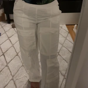 Vita cargopants med fickor - Snygga vita cargopants med flera praktiska fickor. Byxorna har en loose passform och är perfekta för en avslappnad stil. De är tillverkade i ett lätt och bekvämt material. Aldrig använda legat bara i garderoben.
