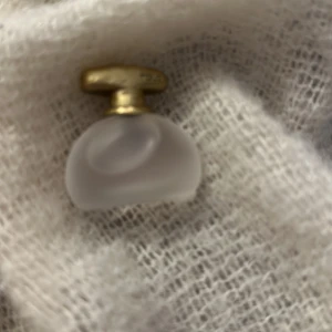 Tous Floral Touch parfym - En elegant parfym från Tous i en liten flaska med frostat glas och guldfärgat lock. Förpackningen är rosa med guldiga blommönster och texten 'Floral Touch'. Perfekt för den som älskar blommiga dofter.