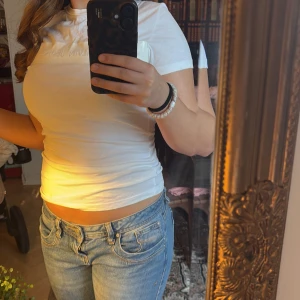 Vit snygg t-shirt från Calvin Klein - Säljer en vit t-shirt med korta ärmar. T-shirten har en tight passform och är perfekt till våren och sommaren. Den är enkel och stilren, vilket gör den lätt att matcha med olika outfits.💕