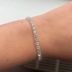 Glittrigt armband i silver - Snyggt armband i silver med glittrande stenar. Armbandet har en justerbar kedja,använder inte silver längre