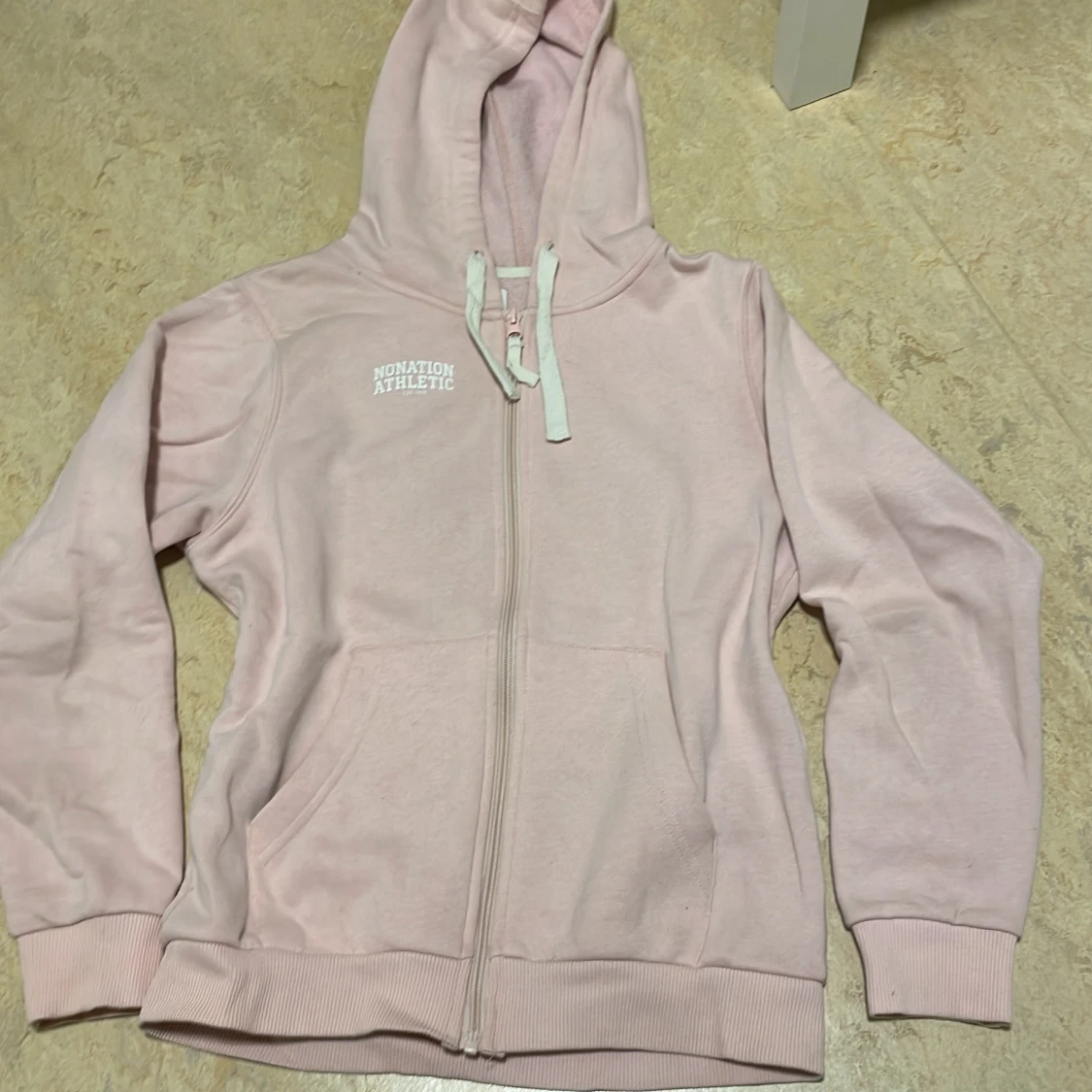 Ljusrosa hoodie från Nonation Athletic