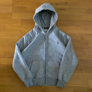 Ralph Lauren Zipup - Tröjan är i mycket bra skick och är gjord i ett skönt och bra material. Den har storleken M, fast passar även S. Kontakta mig och du har några frågor eller om du vill ha fler bilder.