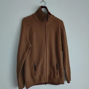 Brun kofta från Massimo Dutti - Säljer en snygg brun kofta från Massimo Dutti med dragkedja och hög krage. Koftan har långa ärmar och praktiska fickor med dragkedja. Perfekt för kyligare dagar!