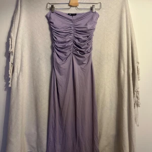 Klänning - Lila tight klänning med rouch framtill. Ny med lapp. Storlek L men passar M