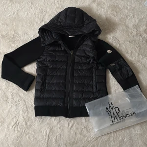 Moncler cardigan (svart) - As fet Moncler cardigan som passar perfekt nu till hösten och kalla sommar dagar. Det är en M men sitter som en S. Självklart äkta! Bild med den på modell som är 178cm lång ser du på bild 5. Du får med 2 extra blixtlås(se bild 3) eftersom jag bytte ut ena till en hel svart men du får med den silvriga som satt där innan och även en Moncler påse. Nypris runt 13k mitt pris endast 3749kr. Hör av dig vid funderingar och pris kan diskuteras vid snabb affär mvh Malte.202💙
