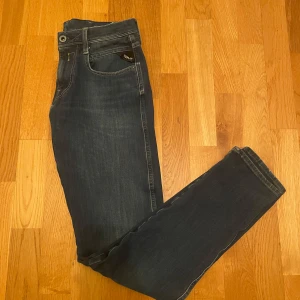 Mörkblå jeans från Replay - Snygga mörkblå jeans från Replay med klassisk femficksdesign och diskreta sömmar. De har en knappgylf och en liten logga på bakfickan. Perfekta för en stilren look.                                                                  Pris går att diskuteras