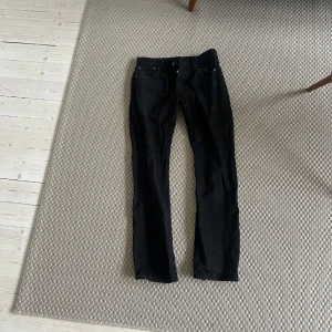 Levis 501 svarta - Snygga svarta jeansbyxor med klassisk design. De har en rak passform och är perfekta för en stilren look. Storlek 30 / 32