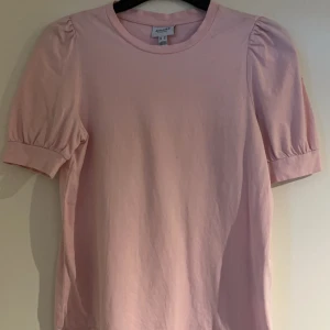 Rosa topp från Aware by Vero Moda - Säljer en söt rosa topp från Aware by Vero Moda. Toppen har korta puffärmar och en rund halsringning. 💖