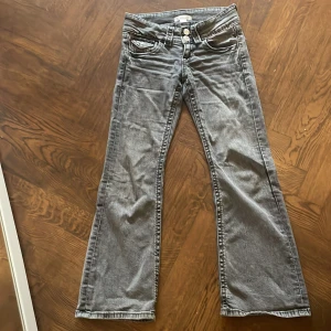 Grå jeans från Gina Tricot - Snygga grå bootcat jeans från Gina Tricot i storlek 134. De har en klassisk femficksdesign och stängs med dragkedja och två knappar. 
