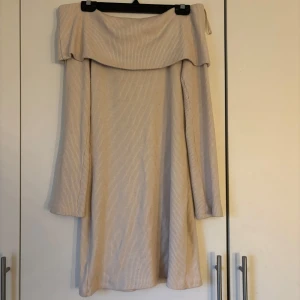 Beige ribbad klänning från Gina Tricot - Säljer en beige ribbad klänning från Gina Tricot. Klänningen har en offshoulder-design och långa ärmar. klänningen är i storlek L men har sytt in den i midjan så den passar S och M, det är stretchig.