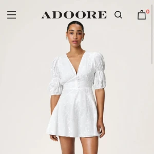 Vit klänning från ADOORE - Vit klänning med v-ringning och korta puffärmar. Klänningen har en figursydd passform med ett lite broderat blommigt mönster och en kort längd. Perfekt som studentklänning, vilket var enda tillfället jag använde klänningen. Jag kan verkligen rekommendera den till studentdagen! Hoppas någon av er blir lika nöjd som jag var med klänningen!