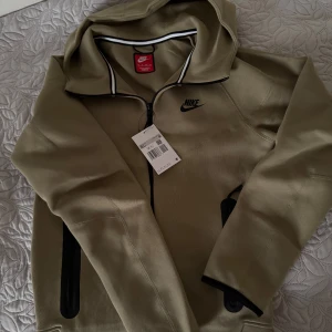 Nike tech fleece - Säljer denna fina beige tröjan som är helt oanvänd, inte ens testad, köpt direkt från Nike och säljer för att jag fick bra erbjudande då jag är medlem. En sån här tröja från Nike helt ny kostar 1499kr. Den är storlek XS men passar S också. Bara höra av sig vid frågor!