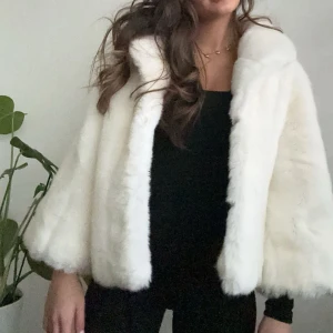 Vit pälsjacka - Säljer en elegant vit pälsjacka med trekvarts ärmar. Jackan har en lyxig känsla och är perfekt för att hålla dig varm och stilren under kallare dagar. 