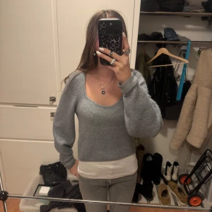 Grå stickad tröja från H&M - Säljer en mysig grå stickad tröja från H&M. Tröjan har en rund halsringning och långa ärmar, perfekt för kyligare dagar. Enkel och stilren design som passar till det mesta.