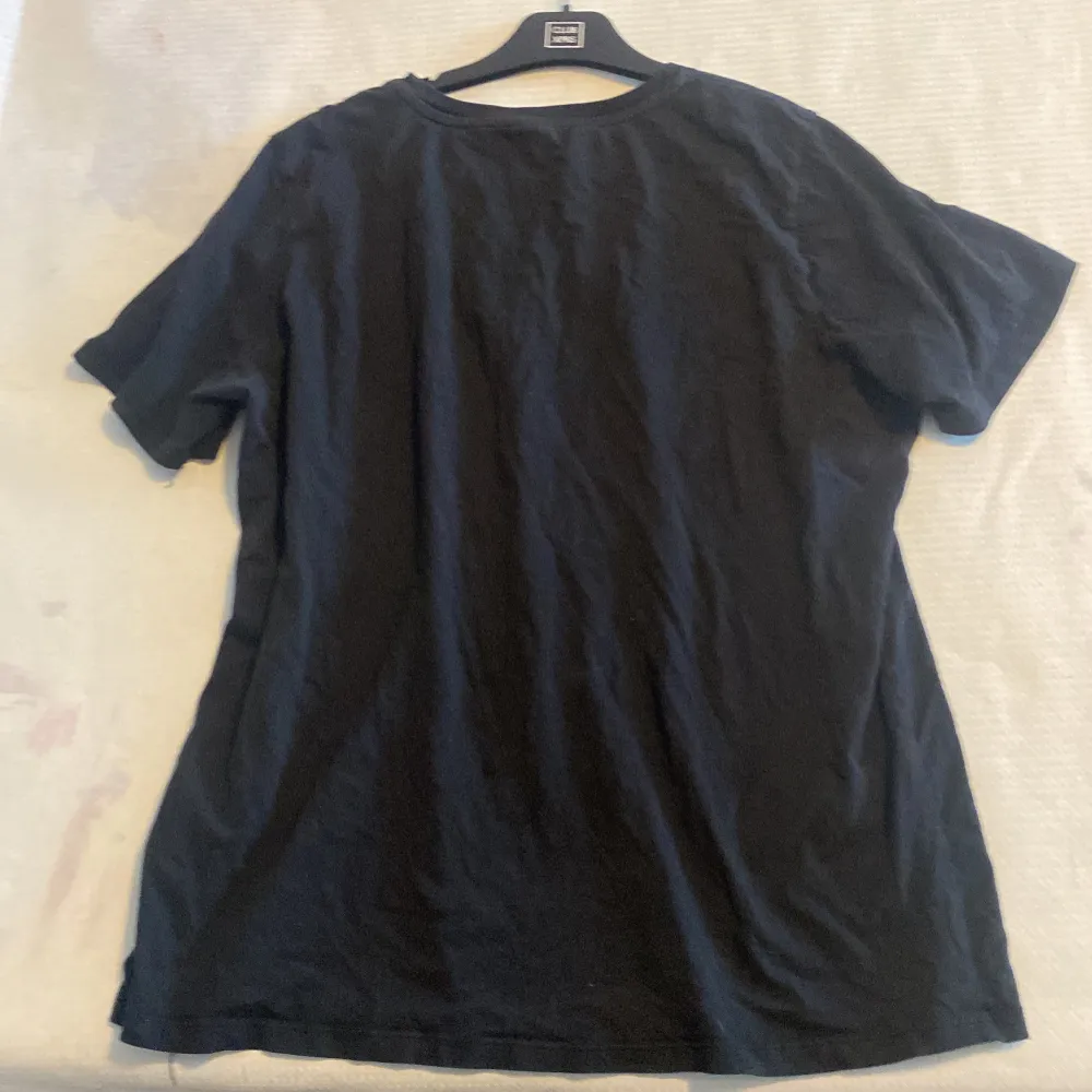 Snygg svart t-shirt från Gina Tricot med ett konstnärligt tryck och texten 'ROMANCE' på framsidan. Perfekt för en avslappnad stil med en touch av konst. Det står XL men den är nästan lika stor som en M-L. . T-paidat.
