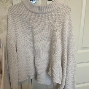 Vit stickad tröja  - Fin vit stickad tröja från Gina Tricot med en avslappnad passform. Perfekt för kyliga dagar med sin ribbade design och långa ärmar. En stilren och bekväm tröja för alla tillfällen. Knappt använd! 