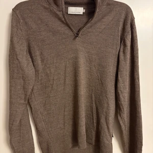 Brun tröja med dragkedja från Casual Friday - Snygg brun tröja från Casual Friday med dragkedja vid halsen. Perfekt för kyligare dagar med sin långärmade design. Enkel och stilren, passar till många olika outfits.