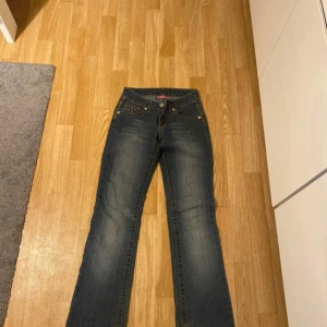 Blå jeans från KappAhl - Snygga blå jeans från KappAhl med dekorativa detaljer på bakfickorna. De har en klassisk femficksdesign och en bekväm passform. Perfekta för en avslappnad stil.