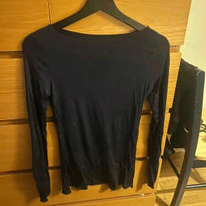 Mörkblå långärmad topp från Intimissimi - Säljer en stilren mörkblå långärmad topp från Intimissimi. Perfekt för lager-på-lager eller som den är. Toppen har en enkel design med rund halsringning. Den är använd 10 tal gånger och är i bra skick.