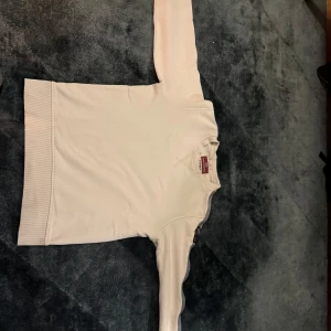 Vit fleece tröja från Parajumpers - Säljer en vit fleece tröja från Parajumpers med ett snyggt märke på ärmen. Tröjan har en klassisk passform och är perfekt för kyliga dagar. Den är mjuk och bekväm, idealisk för både vardag och äventyr. Min lillebror som är 178 cm, tröjan passar honom bra. Pris kan diskuteras 