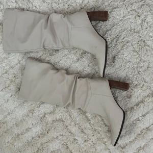 Stövletter  - Snygga beige stövlar med träklack och spetsig tå. Perfekta för fest. Använda några gånger. Köpta för 900kr. Stl 38 och normala i storleken ☺️💕