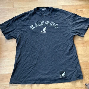 Oversized t-shirt från Kangol - Snygg svart t-shirt från Kangol med deras ikoniska logga tryckt på bröstet. Perfekt för en avslappnad stil. Använd några gånger men i fint skick & 100 % bomull så skönt material 🖤