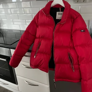 Röd dunjacka från Tommy Hilfiger - Snygg röd dunjacka från Tommy Hilfiger. Använt ett fåtal gånger men ser helt ny ut.