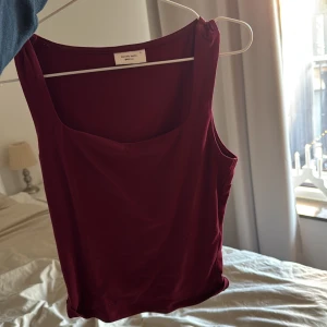 Vinröd linnetopp från Gina tricot  - Snygg vinröd linnetopp från Gina med breda axelband och rund halsringning. Perfekt för lager-på-lager eller som den är. Enkelt och stilrent plagg för alla tillfällen.