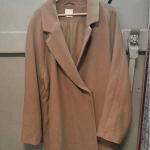 Snygg beige kappa från H&M i en klassisk design. Perfekt för höst och vår med sin stilrena look och långa ärmar. Kappan har en elegant krage och är tillverkad i ett mjukt material. Pris kan diskuteras