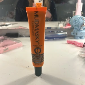 POREfining Glow Mask från Mudmasky - En orange tub med POREfining Glow Mask från Mudmasky. Denna mask är designad för att sudda ut porer, korrigera och återfukta huden. Perfekt för att ge en jämn och strålande hy.