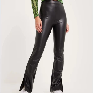Svarta skinnleggings bootcut - Nypris: 399:- svarta leggings i skinnimitation med elastisk midja. Bootcut med slits. Perfekta för en trendig look och kan enkelt matchas med olika toppar och skor.